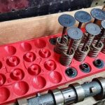 Disassembled plastic push pull valve showing internal components and repair tools